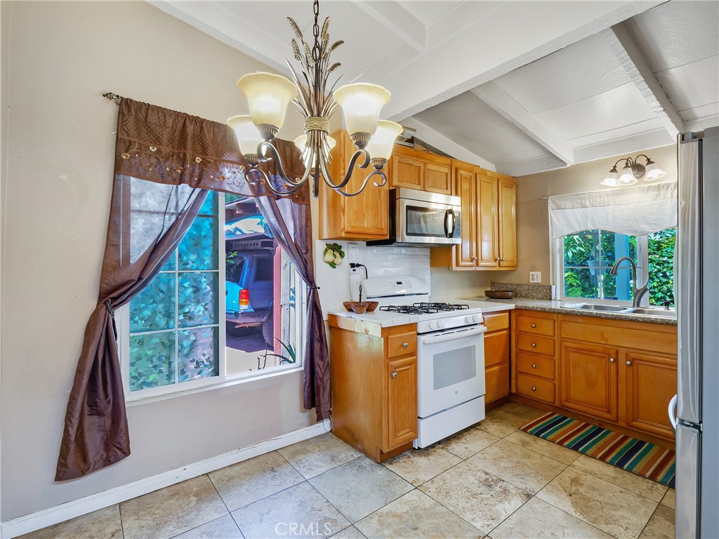 820 Raintree Place Vista, CA 92084 - Photo 8 of 29 a kitchen with stainless steel appliances granite countertop a stove a sink and a microwave
