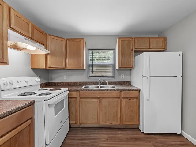 a kitchen with a stove a refrigerator and a sink