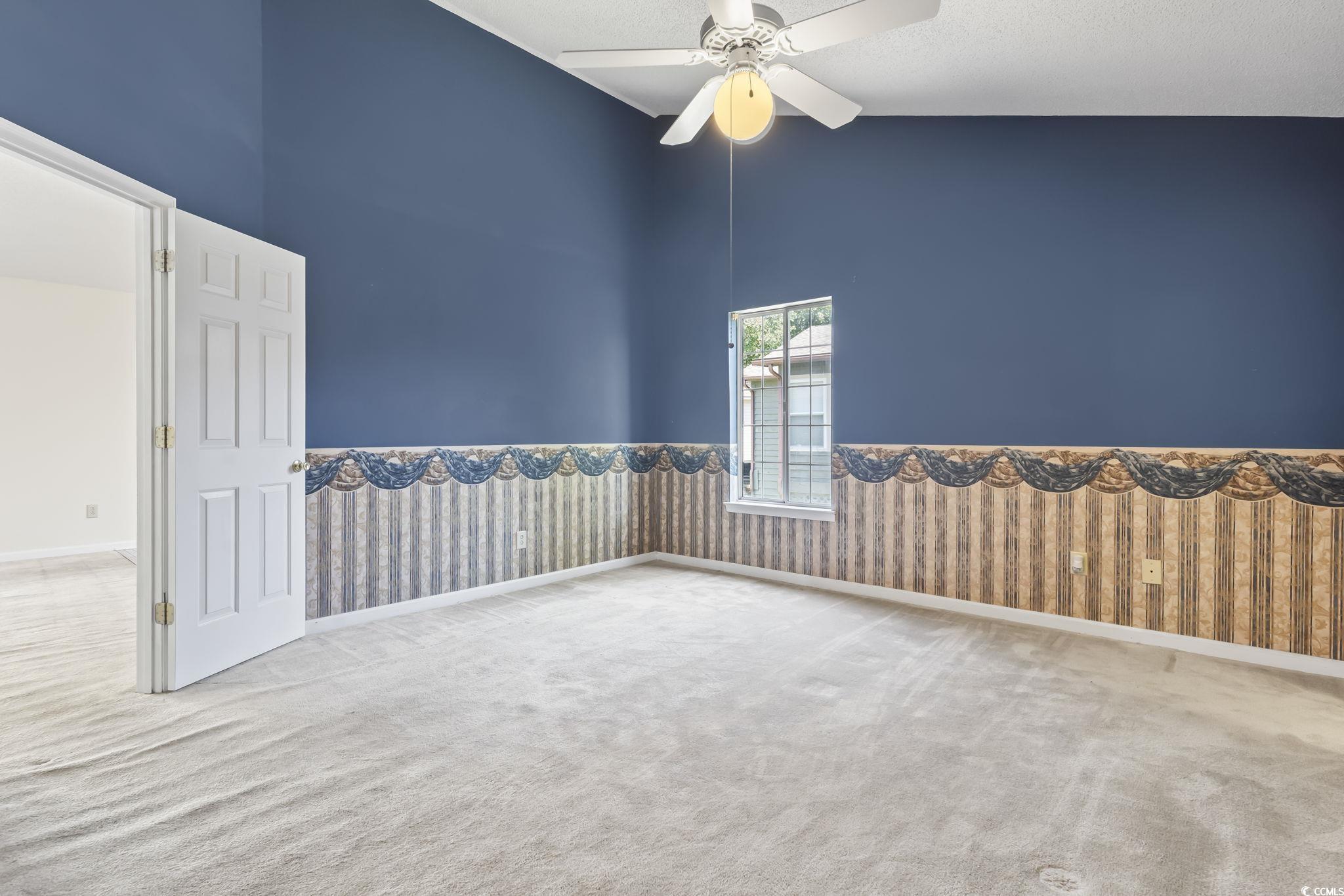 914 Dock Place Murrells Inlet, SC 29576 - Photo 17 of 37 Carpeted empty room with high vaulted ceiling, ceiling fan, and wainscoting
