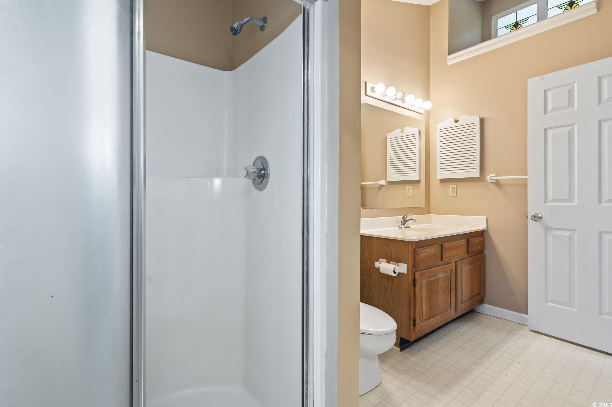 914 Dock Place Murrells Inlet, SC 29576 - Photo 21 of 37 Full bathroom featuring a stall shower, vanity, toilet, and baseboards