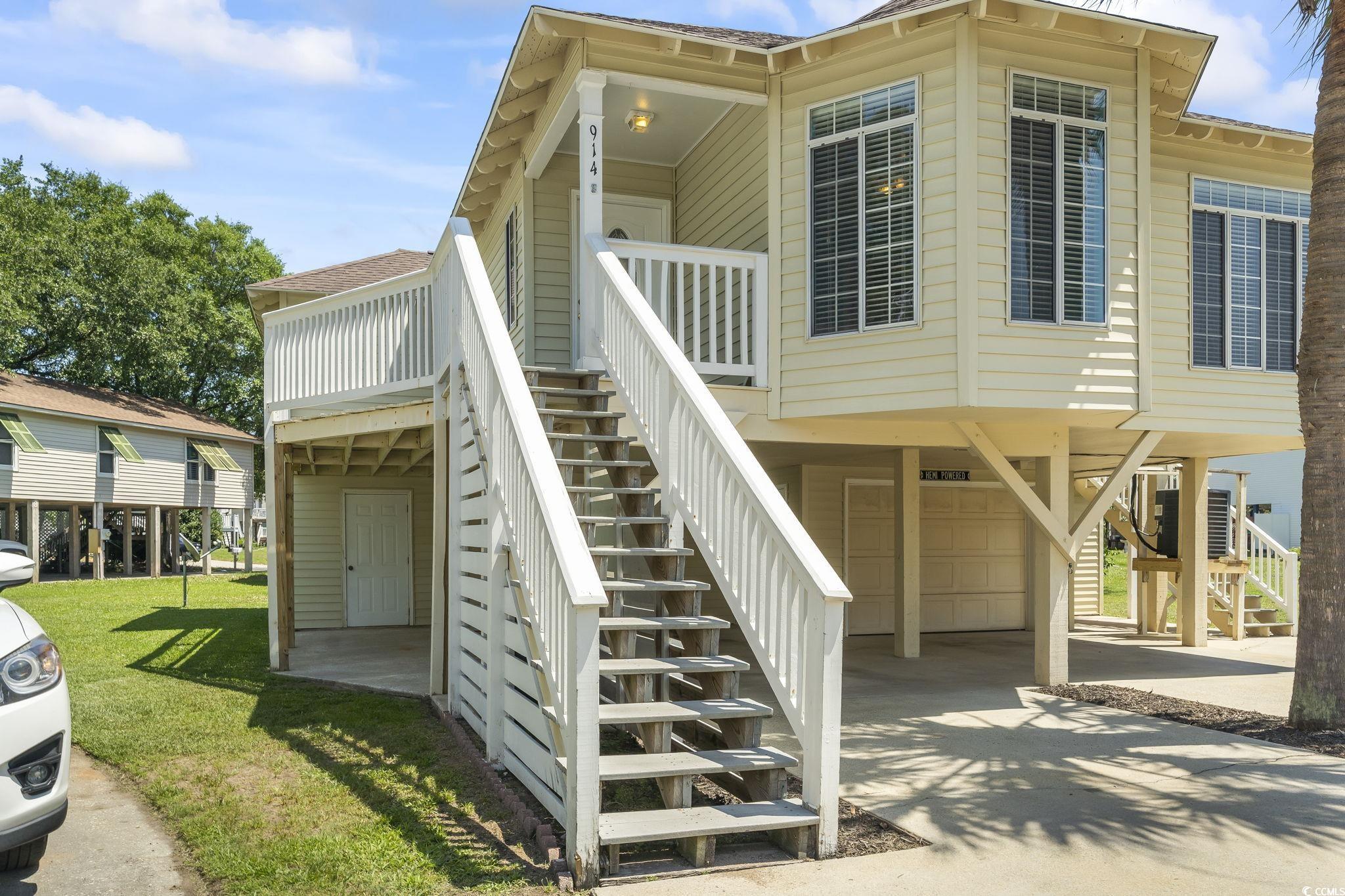 914 Dock Place Murrells Inlet, SC 29576 - Photo 5 of 37 View of property exterior with stairs, a carport, an attached garage, concrete driveway, and a yard