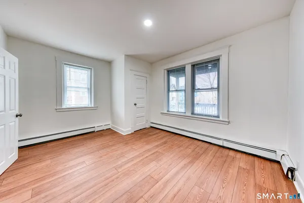 an empty room with wooden floor and windows