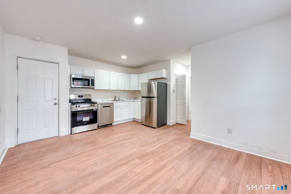 a kitchen with stainless steel appliances granite countertop a refrigerator and a stove top oven