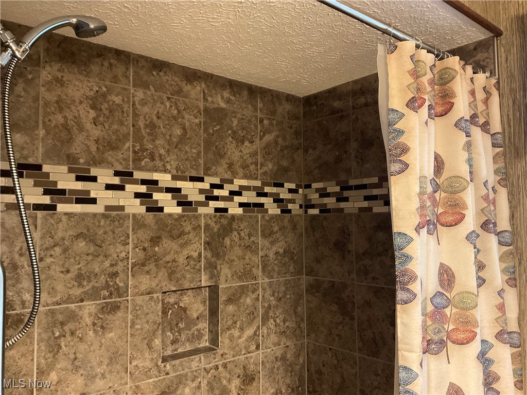 7345 Roller Road Salem, OH 44460 - Photo 22 of 50 Bathroom view of a tile shower and a textured ceiling