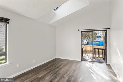 an empty room with wooden floor and a window