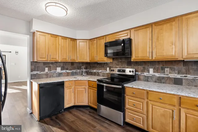 a kitchen with granite countertop cabinets stainless steel appliances a sink and a window