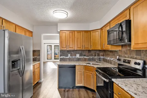 a kitchen with a sink a refrigerator and cabinets