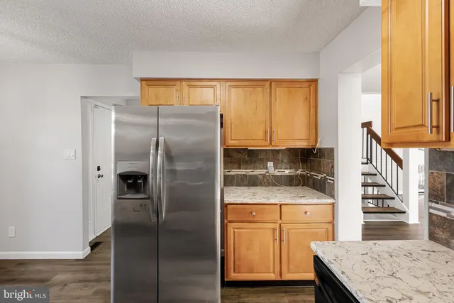 a kitchen with stainless steel appliances granite countertop a refrigerator and a stove