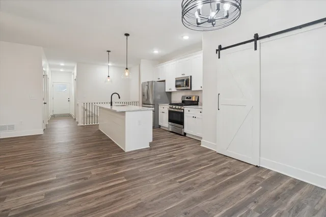 a kitchen with granite countertop a stove a sink a refrigerator and a fireplace