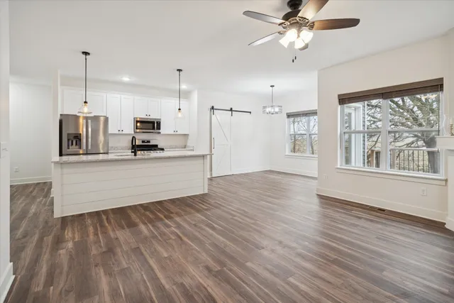 a large kitchen with cabinets wooden floor and a stainless steel appliances