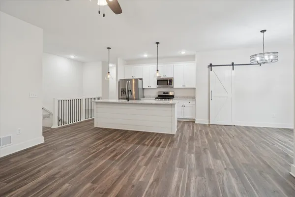 a large kitchen with cabinets wooden floor and a stainless steel appliances