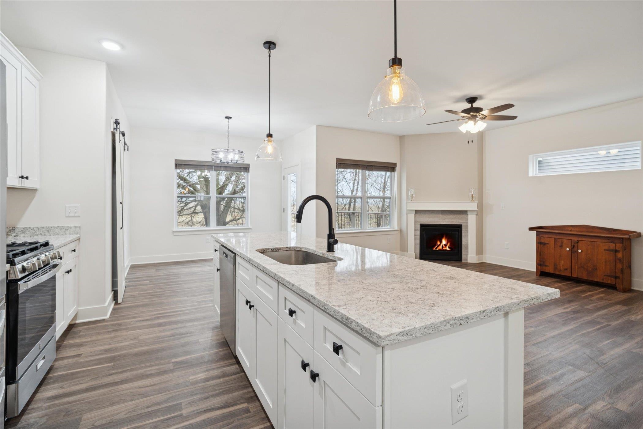 505 Anjali Court Sycamore, IL 60178 - Photo 32 of 47 a kitchen with granite countertop a stove a sink a refrigerator and a fireplace