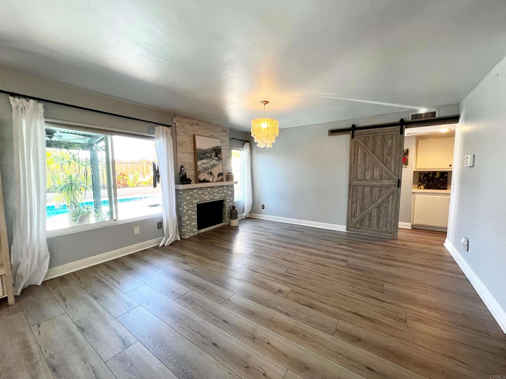 3583 Hatfield Circle Oceanside, CA 92056 - Photo 15 of 32 an empty room with wooden floor fireplace and windows