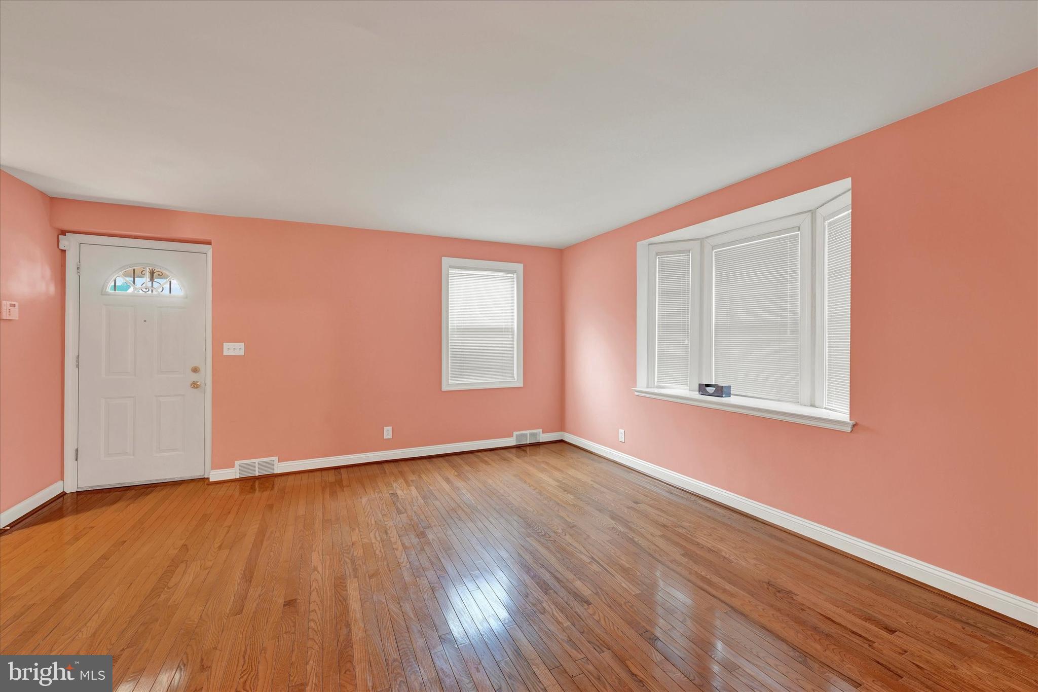 4010 Brookhill Road Baltimore, MD 21215 - Photo 5 of 26 a view of an empty room with wooden floor and a window