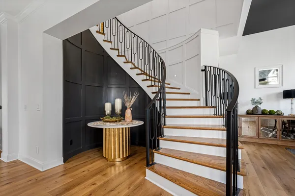 a kitchen with stainless steel appliances kitchen island granite countertop a table chairs and a wooden floor