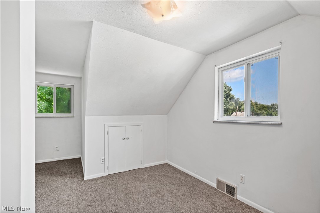 1286 Deforest Road Southeast Warren, OH 44484 - Photo 14 of 27 Room featuring sloped ceilings, two single-pane windows, and gray carpeted flooring