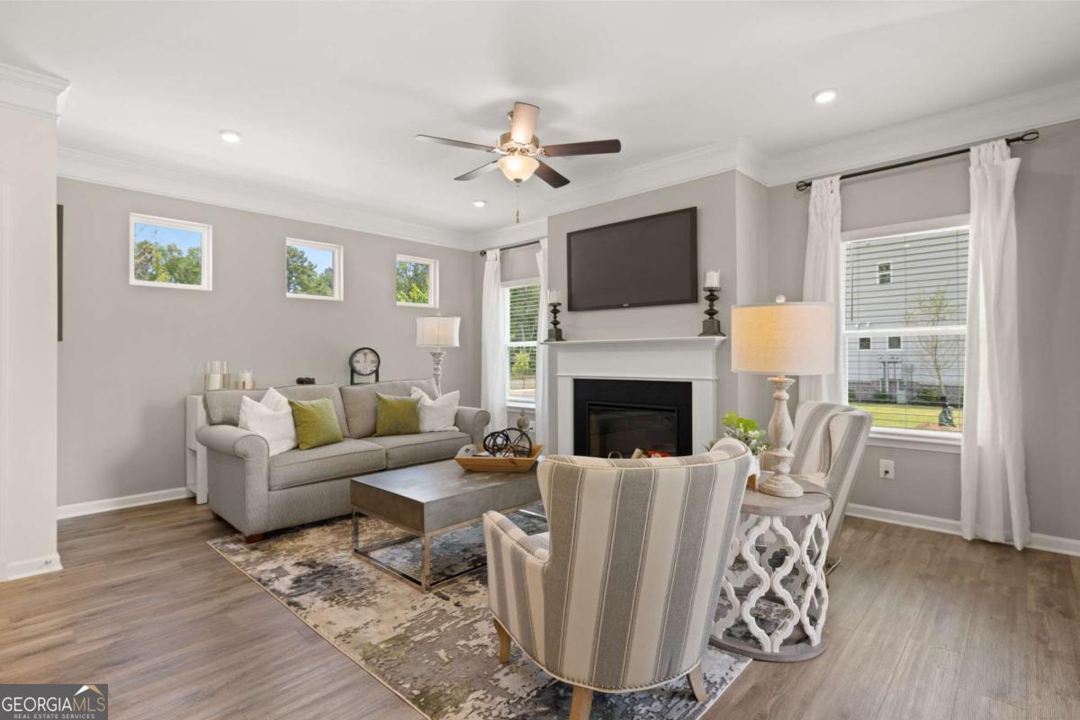 1429 Trellis Court, Unit (LOT 9) Hampton, GA 30228 - Photo 11 of 28 a living room with furniture a fireplace and a flat screen tv