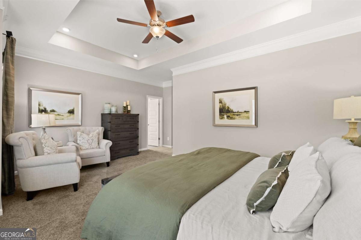 1429 Trellis Court, Unit (LOT 9) Hampton, GA 30228 - Photo 16 of 28 a spacious bedroom with a bed and a couch