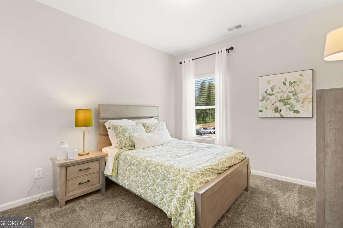 1429 Trellis Court, Unit (LOT 9) Hampton, GA 30228 - Photo 23 of 28 a bedroom with a bed and painting on the wall