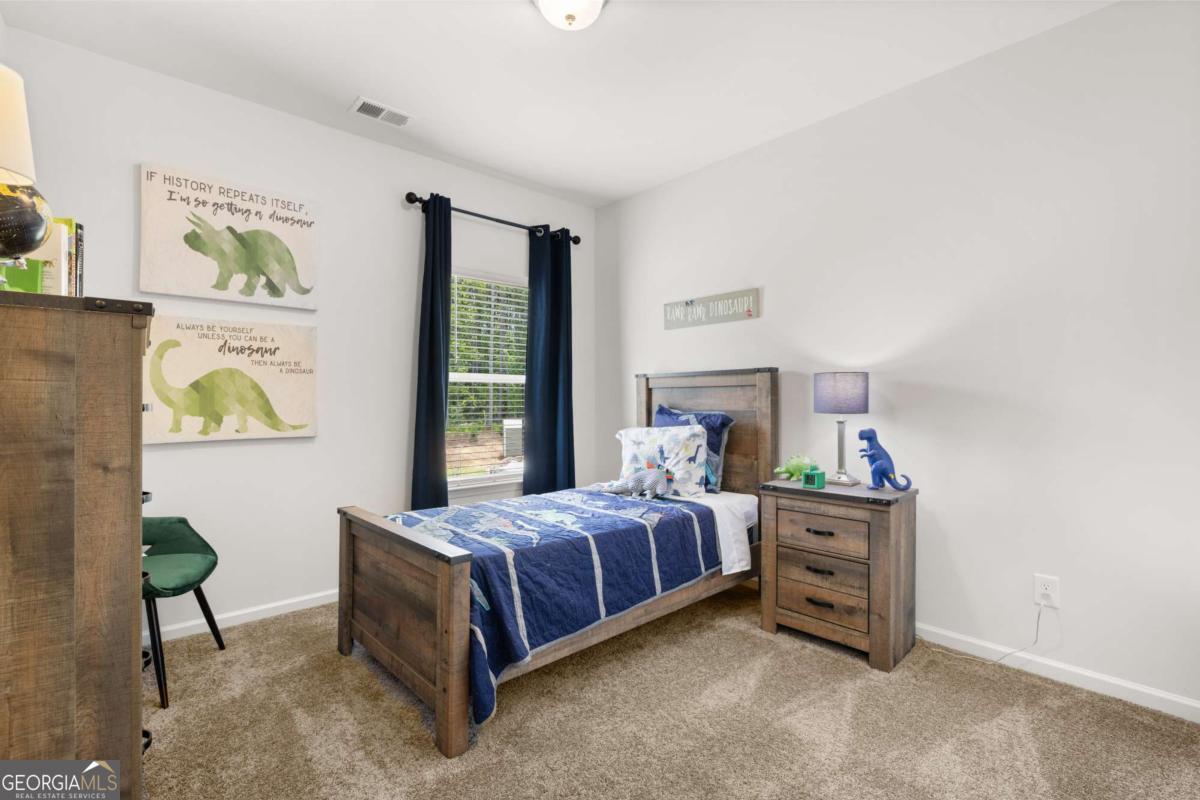 1429 Trellis Court, Unit (LOT 9) Hampton, GA 30228 - Photo 25 of 28 a bedroom with a bed table and a window