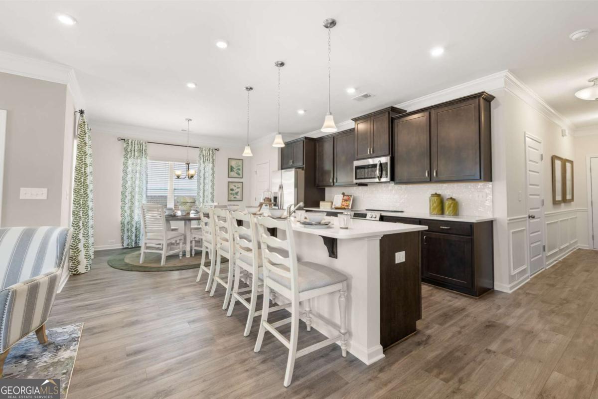1429 Trellis Court, Unit (LOT 9) Hampton, GA 30228 - Photo 5 of 28 a large kitchen with a table and chairs