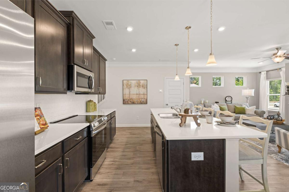 1429 Trellis Court, Unit (LOT 9) Hampton, GA 30228 - Photo 7 of 28 a kitchen with sink stove and cabinets