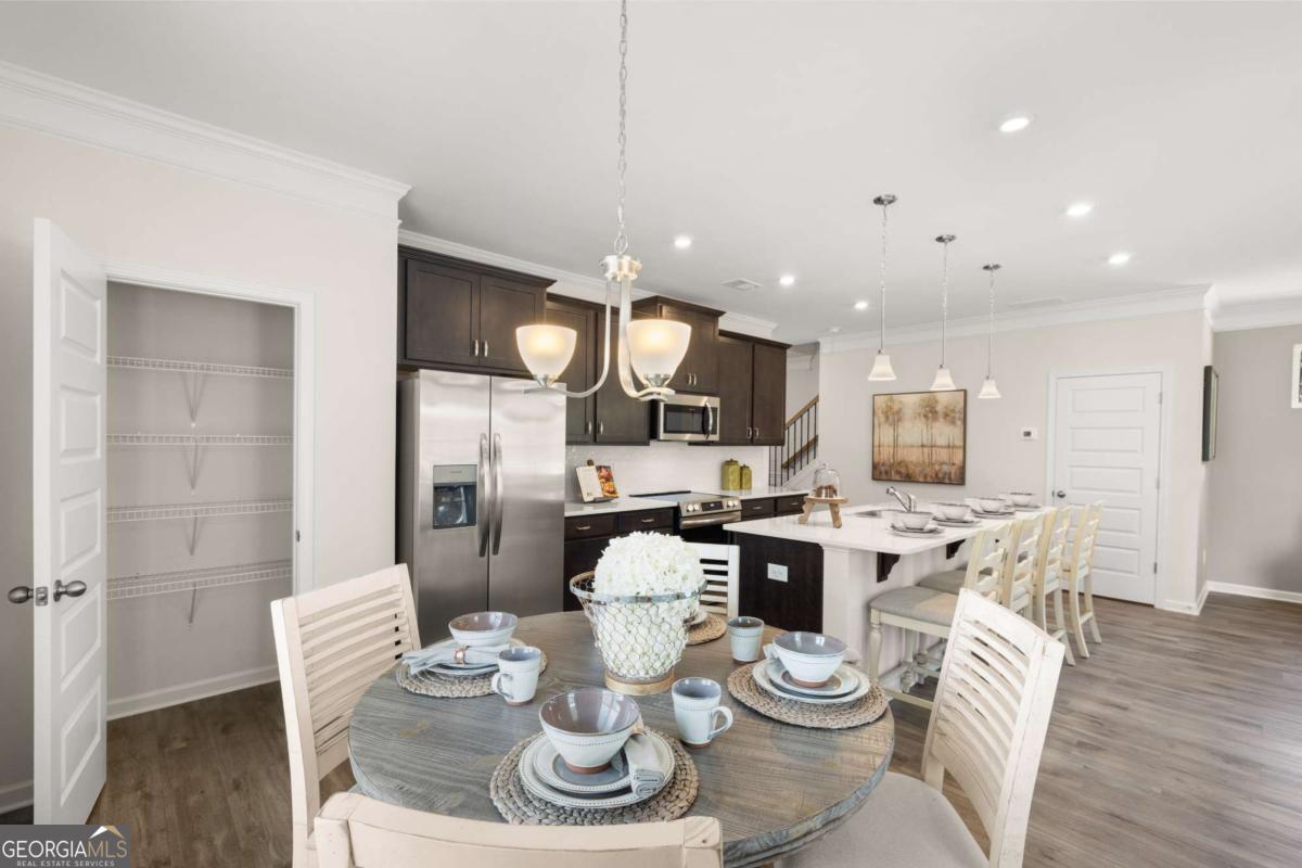 1429 Trellis Court, Unit (LOT 9) Hampton, GA 30228 - Photo 9 of 28 a kitchen with stainless steel appliances kitchen island granite countertop a dining table and chairs