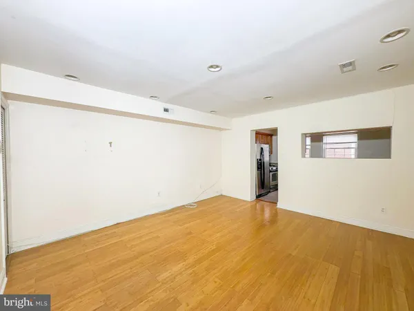 a view of empty room with wooden floor
