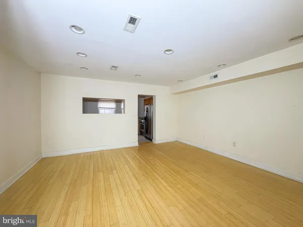 a view of empty room with wooden floor