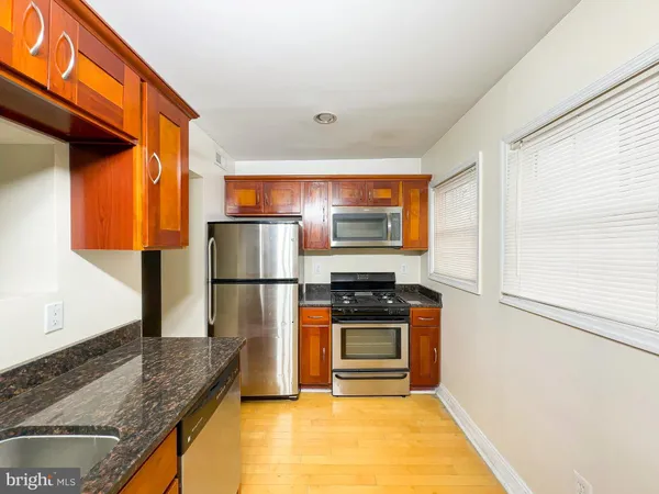 a kitchen with stainless steel appliances granite countertop a refrigerator stove and oven