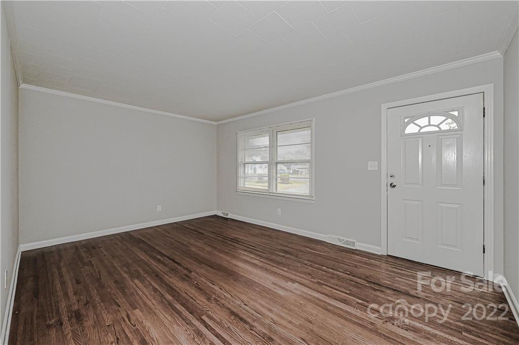 799 Sunderland Road Southwest Concord, NC 28027 - Photo 12 of 26 a view of an empty room with wooden floor and a window