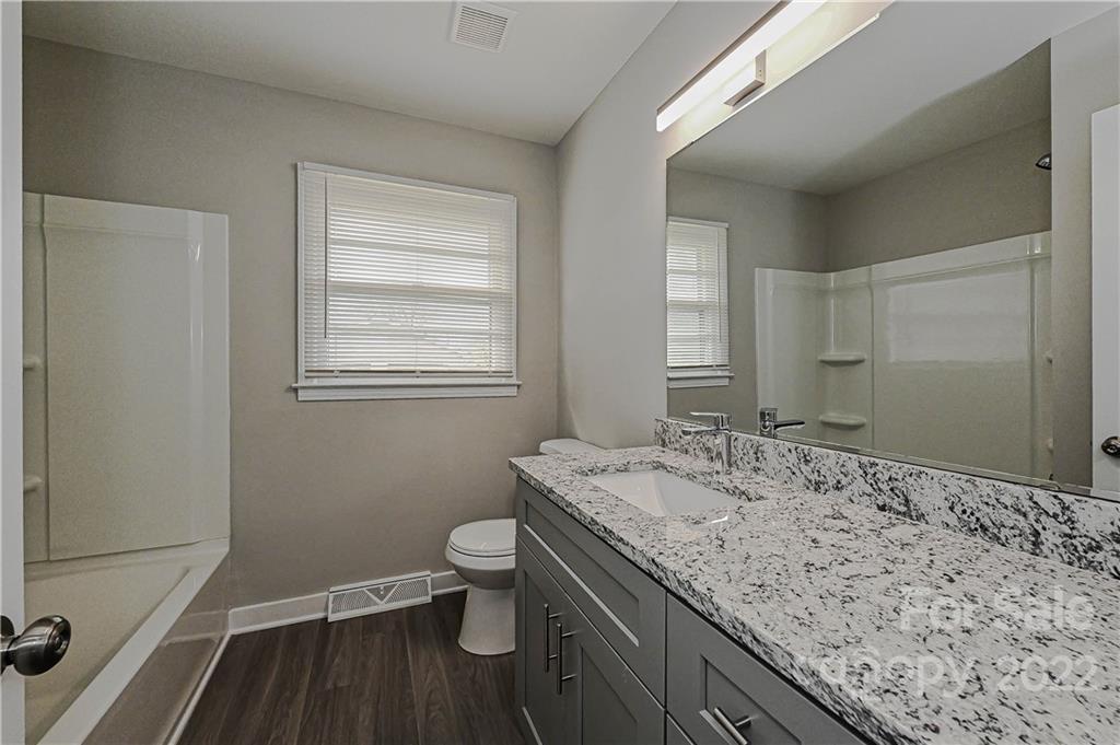 799 Sunderland Road Southwest Concord, NC 28027 - Photo 15 of 26 a bathroom with a granite countertop sink a toilet and a mirror