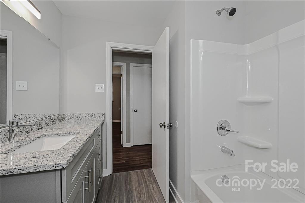 799 Sunderland Road Southwest Concord, NC 28027 - Photo 16 of 26 a bathroom with a granite countertop sink a mirror and shower