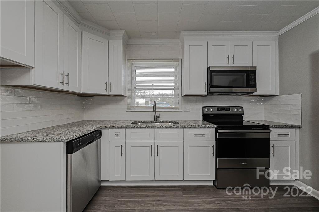 799 Sunderland Road Southwest Concord, NC 28027 - Photo 2 of 26 a kitchen with stainless steel appliances granite countertop a stove a sink and a microwave
