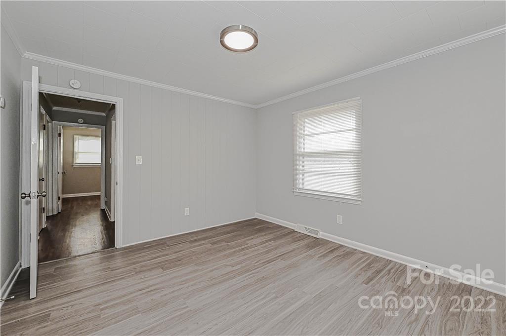799 Sunderland Road Southwest Concord, NC 28027 - Photo 8 of 26 an empty room with wooden floor and windows