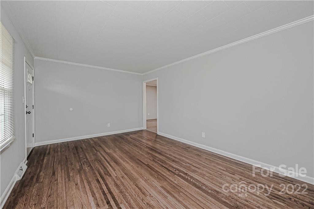 799 Sunderland Road Southwest Concord, NC 28027 - Photo 10 of 26 a view of an empty room with wooden floor and a window