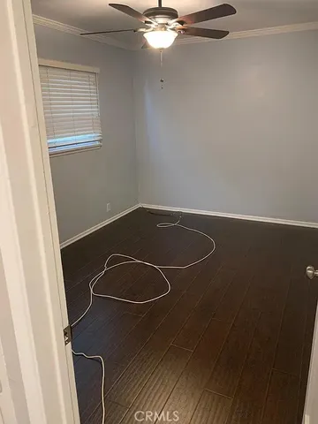an empty room with a chandelier fan