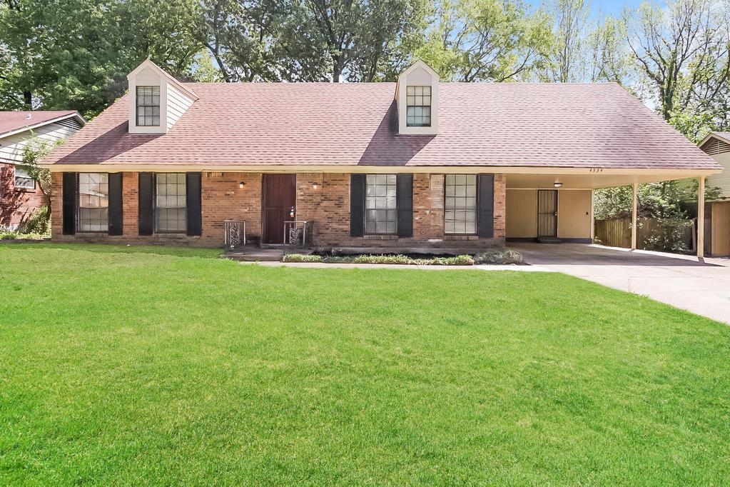 a front view of a house with a yard and trees