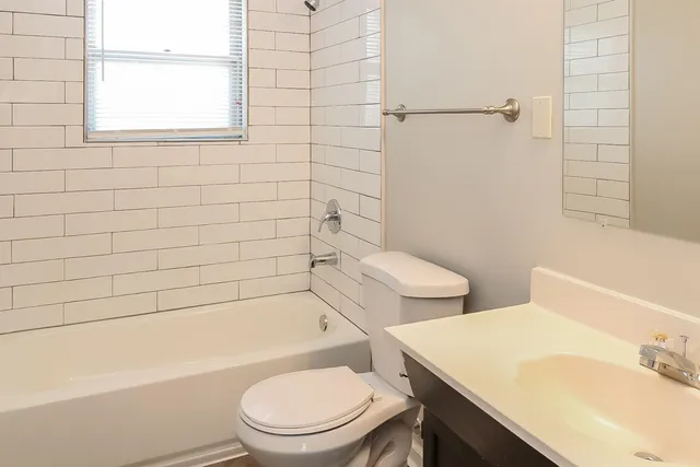 a white toilet sitting next to a bath tub