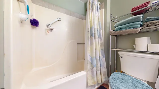 a bathroom with a toilet and a shower curtain