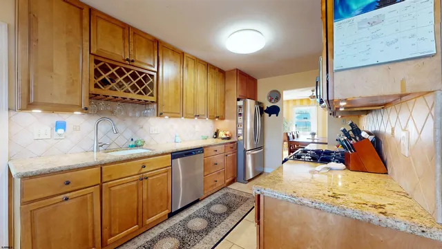 a kitchen with stainless steel appliances granite countertop sink stove and refrigerator