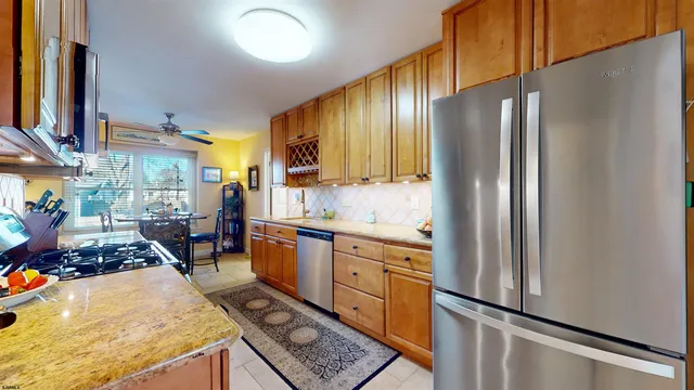 a kitchen with stainless steel appliances granite countertop a refrigerator stove and sink