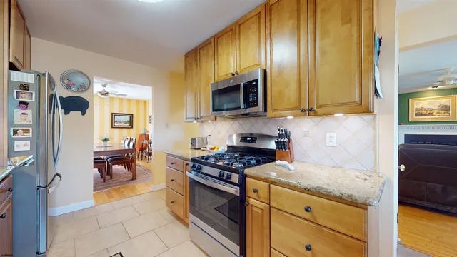 a kitchen with stainless steel appliances granite countertop a stove a sink and a microwave