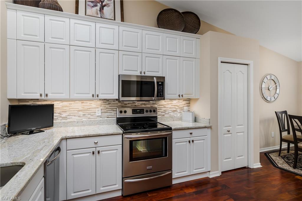 6658 Castlelawn Place, Unit 9 Naples, FL 34113 - Photo 8 of 38 Kitchen featuring a stainless steel undermount sink, granite countertops, white cabinetry, and a stainless steel dishwasher
