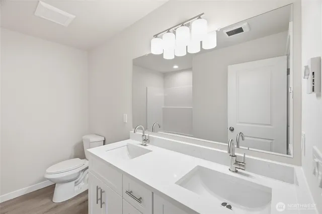 a bathroom with a sink a toilet and a mirror