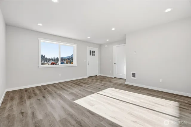 a view of empty room with wooden floor