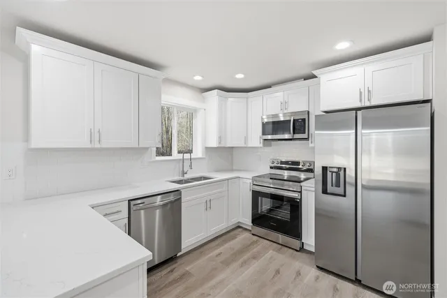 a kitchen with a sink stainless steel appliances and cabinets
