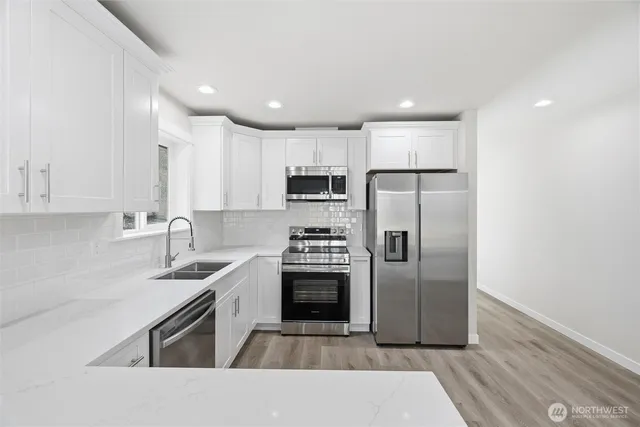 a kitchen with kitchen island a counter top space stainless steel appliances and cabinets