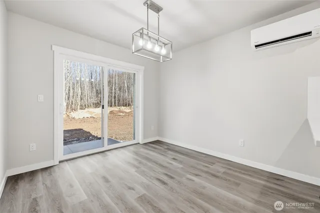 an empty room with wooden floor mirror and windows