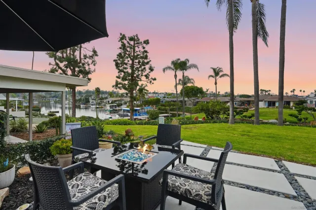 a view of a patio with couches table and chairs under an umbrella